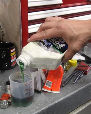 A good quality fork oil, like Spectro fork oil, and in just the right quantity is required for optimum operation of telescopic forks. Here we see Craig carefully measuring the amount.