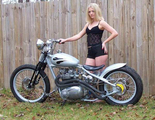 blonde in black standing silver bike